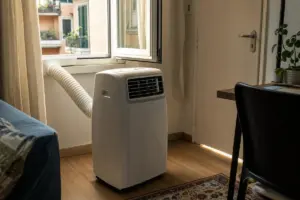 Condizionatore portatile con tubo di scarico collegato a una finestra socchiusa in un soggiorno