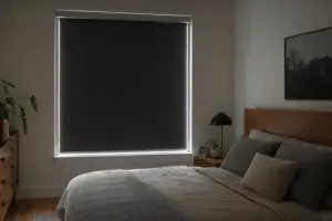 Camera da letto moderna con tenda oscurante a rullo nera in finestra, con sottili guide laterali e luce ai bordi