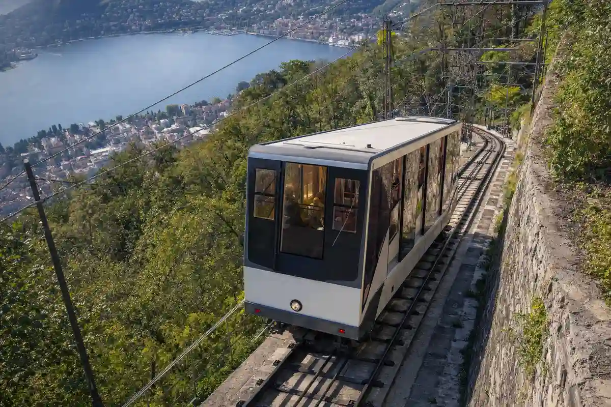 Vettura della funicolare Como-Brunate in salita sul ripido binario, con il Lago di Como sullo sfondo