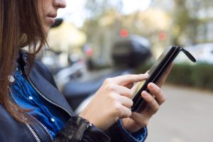 Portrait of beautiful young woman using her mobile phone in the street.