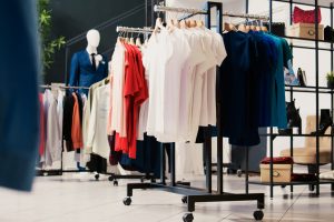 Empty modern boutique in shopping centre, new fashion collection on racks. Fashionable clothes on hangers, clothing store filled with merchandise and accessories at discount for clients