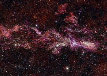 This image shows the complex distribution of molecular gas in the Central Molecular Zone (CMZ) of the Milky Way. It was obtained with the Atacama Large Millimeter/submillimeter Array (ALMA), in which ESO is a partner. This map is as long as three full Moons side-by-side in the sky, and it is in fact the largest ALMA image ever obtained.
 This map is part of ACES — the ALMA CMZ Exploration Survey — a project designed to understand how gas condenses into stars in the extreme and chaotic environment at the heart of our galaxy. The survey has charted the distribution of dozens of different molecules, five of which are shown here in different colours: sulphur monoxide (cyan), silicon monoxide (green), isocyanic acid (red), cyanoacetylene (blue), and carbon monosulphide (magenta).
 The stars in the foreground of this image were observed at infrared wavelengths (Y, Z and J filters) with ESO’s VISTA telescope as part of a different project. The actual density of stars in the CMZ is much higher than what is shown here, where we have opted to highlight the details in the molecular cloud. Note that the edges of the ALMA map appear somewhat sharp because the ALMA observations do not cover the entire rectangular area here.