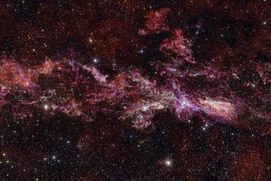 This image shows the complex distribution of molecular gas in the Central Molecular Zone (CMZ) of the Milky Way. It was obtained with the Atacama Large Millimeter/submillimeter Array (ALMA), in which ESO is a partner. This map is as long as three full Moons side-by-side in the sky, and it is in fact the largest ALMA image ever obtained.
 This map is part of ACES — the ALMA CMZ Exploration Survey — a project designed to understand how gas condenses into stars in the extreme and chaotic environment at the heart of our galaxy. The survey has charted the distribution of dozens of different molecules, five of which are shown here in different colours: sulphur monoxide (cyan), silicon monoxide (green), isocyanic acid (red), cyanoacetylene (blue), and carbon monosulphide (magenta).
 The stars in the foreground of this image were observed at infrared wavelengths (Y, Z and J filters) with ESO’s VISTA telescope as part of a different project. The actual density of stars in the CMZ is much higher than what is shown here, where we have opted to highlight the details in the molecular cloud. Note that the edges of the ALMA map appear somewhat sharp because the ALMA observations do not cover the entire rectangular area here.