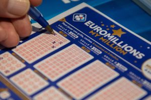 epa08862321 A person plays a EuroMillions grid in Bordeaux, France, 04 December 2020. The jackpot for this draw will reach 200 million euro. Before 2020, the jackpot was capped at 190 million euros.  EPA/CAROLINE BLUMBERG