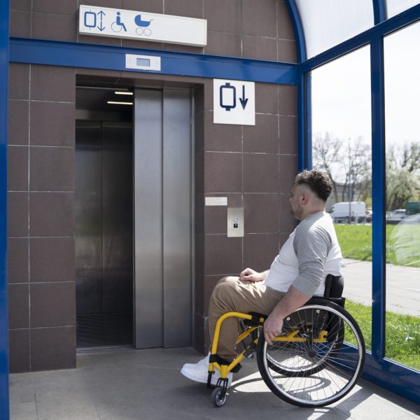 full-shot-disabled-man-taking-elevator