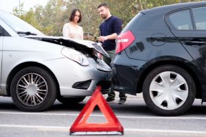 People examining car body damages after car hit