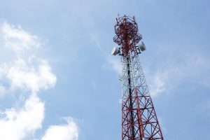 Telecommunications antenna for radio, television and telephone with cloud and blue sky